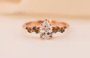 ivy setting with pear .75ct lab diamond and green sapphire
